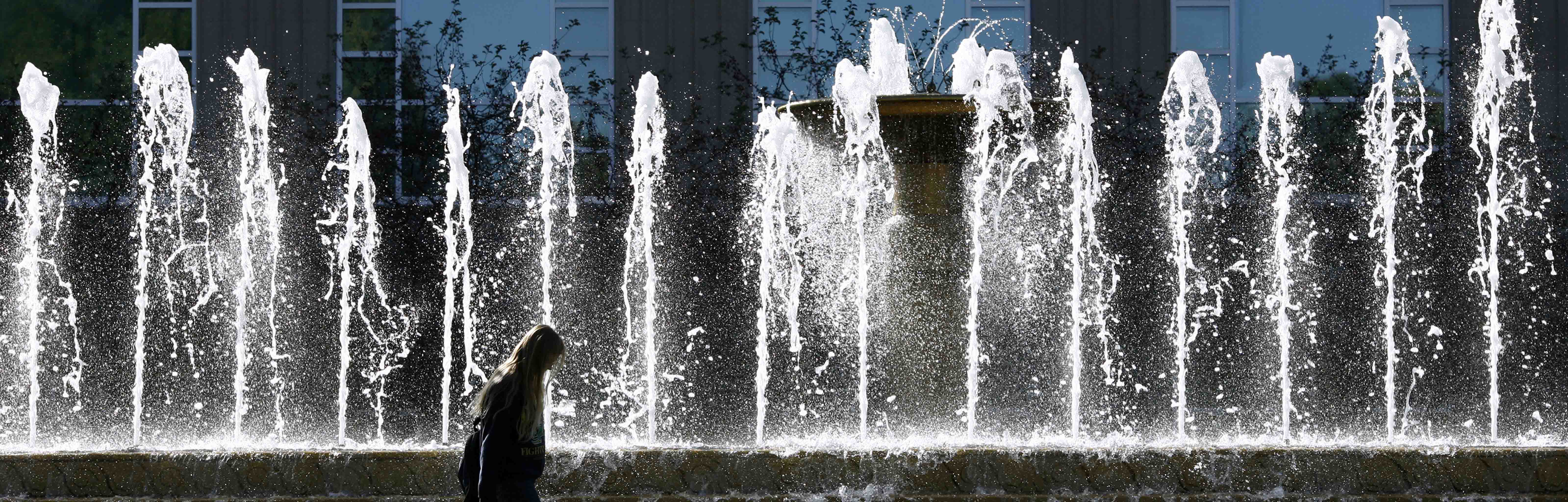 A photograph of a large outdoor fountain in front of a building